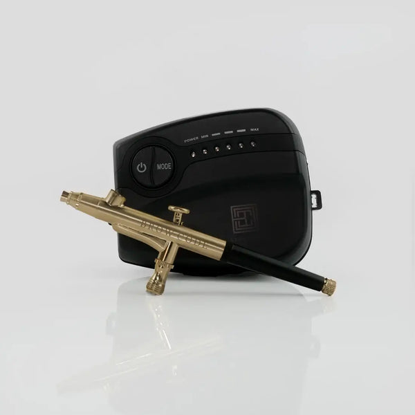 Brow Code Airbrush Machine with a sleek black compressor and a gold airbrush pen, designed for precise and effortless brow tinting