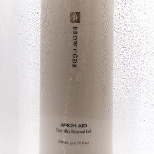 Brow Code Arch Aid Post Wax Renewal Gel behind a steamy glass surface with water droplets, emphasizing hydration and skin relief