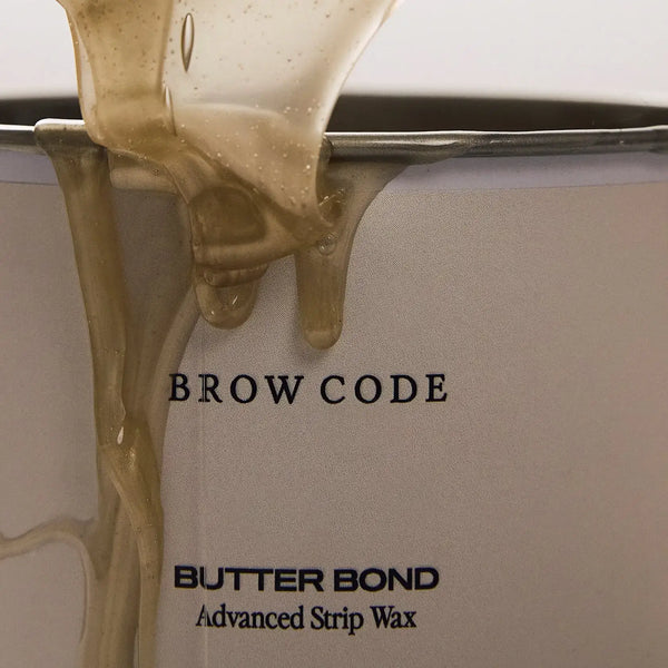 Brow Code Butter Bond Advanced Strip Wax in a beige 400mL tub with white lid, formulated for professional brow waxing and smooth hair removal