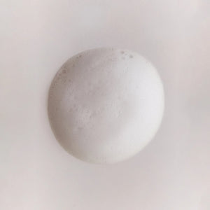 Close-up of a foamy white bubble from Brow Code First Base Ceramide Foaming Cleanser, showcasing its airy, gentle texture on skin
