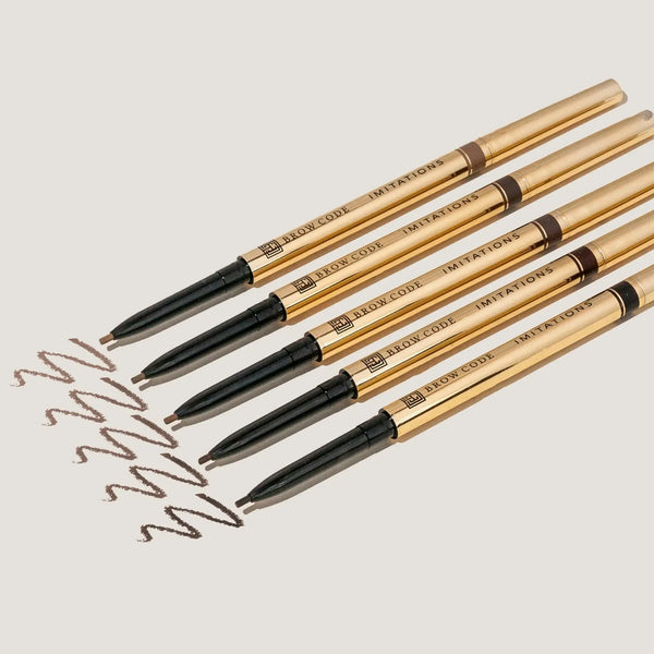 Brow Code Imitations Micro Brow Pencil set in gold packaging, featuring ultra-fine tips for precise, hair-like strokes to enhance and define natural brows