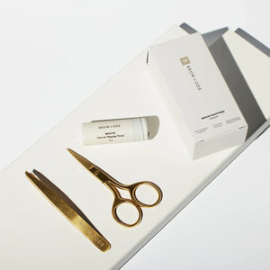 Flat-lay of Brow Code Mapping Kit featuring gold scissors, tweezers, and white charcoal mapping thread on a minimal white background