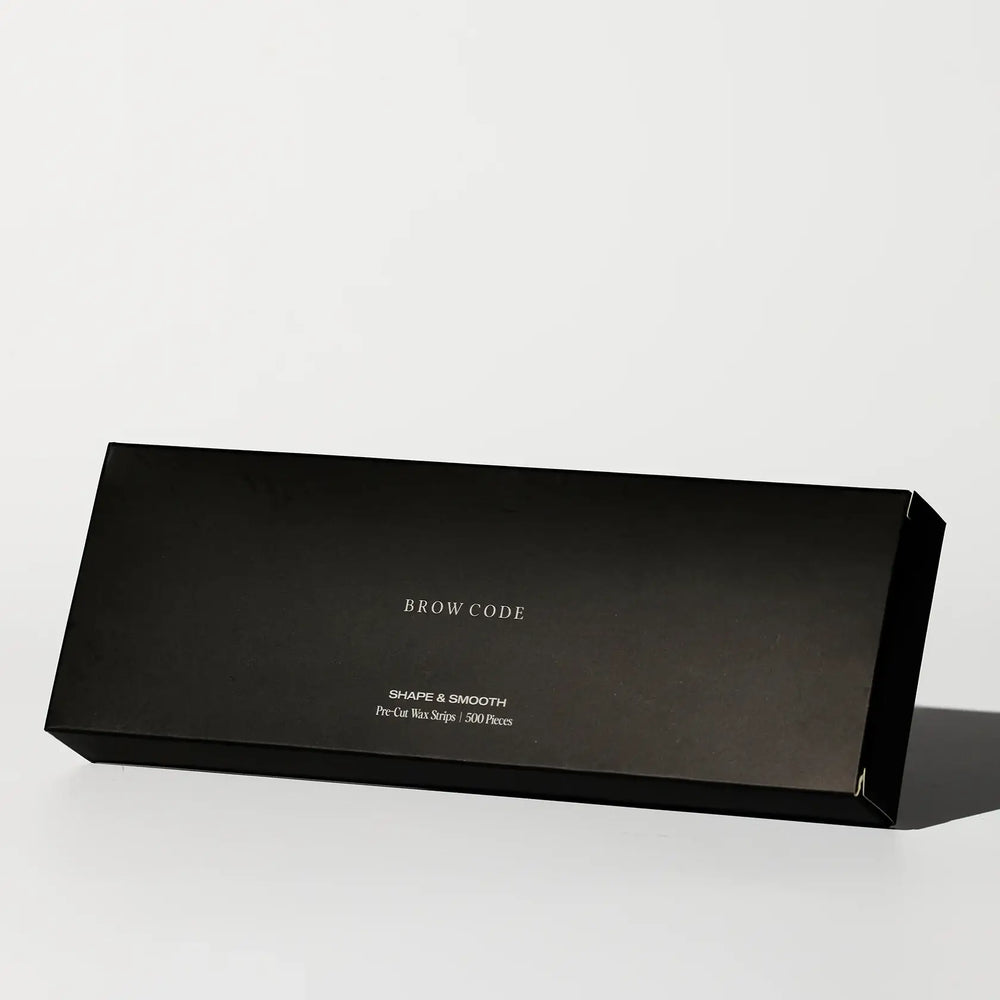 Brow Code Shape & Smooth Pre-Cut Wax Strips in a sleek black rectangular box containing 500 precision strips for eyebrow shaping and waxing