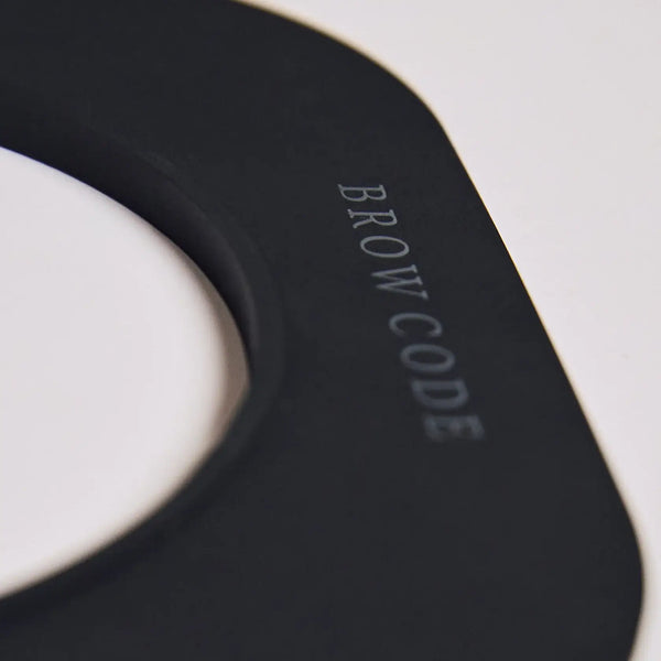 Close-up of Brow Code Silicone Wax Collar in matte black, highlighting embossed logo and smooth finish for professional brow waxing setups