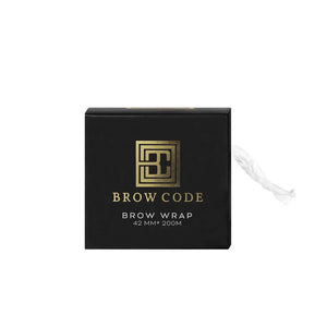 Brow Code Brow Wrap in black and gold packaging with a clear wrap roll dispensing from the side, designed for professional brow lamination treatments