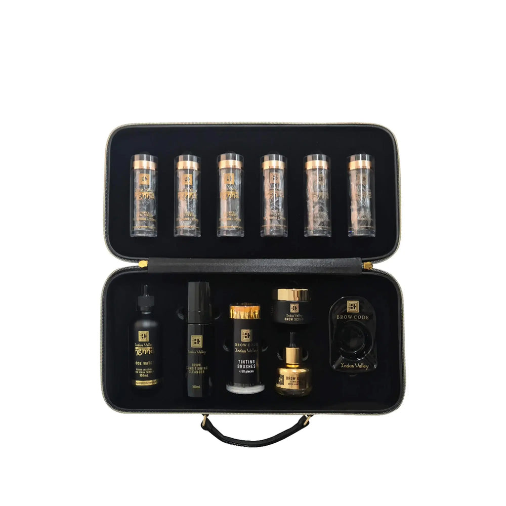 Brow Code Pro Stain Hybrid Dye Kit displayed with henna capsules, tools, and rose water, packed in a sleek black and gold zip case