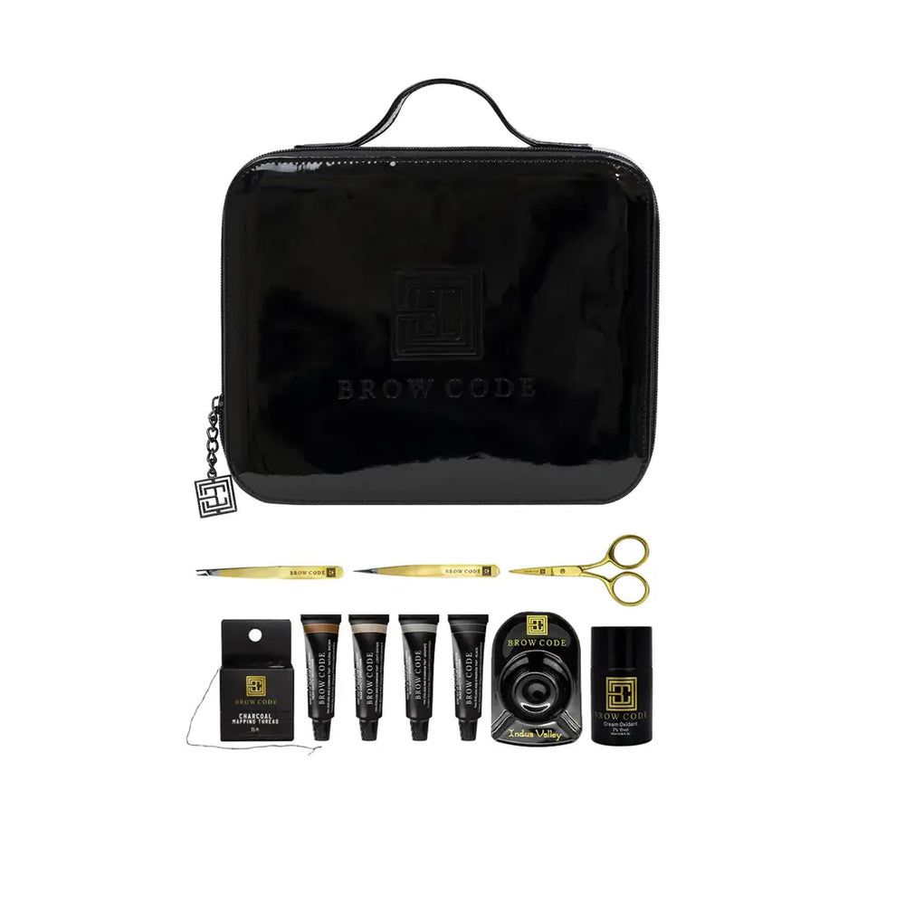 Brow Code Professional Brow Tint Kit with black carrying case, precision tools, five brow tint tubes, charcoal mapping thread, mixing dish, and cream oxidant