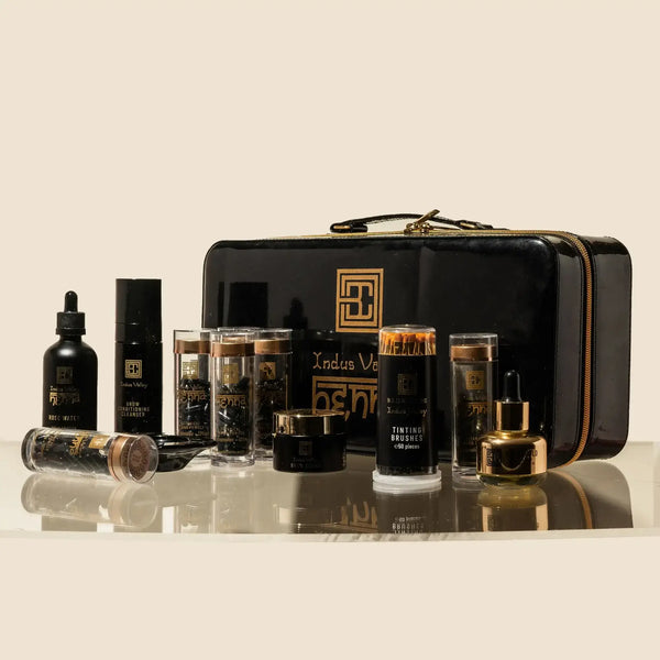Brow Code Pro Stain Hybrid Dye Kit displayed with henna capsules, tools, and rose water, packed in a sleek black and gold zip case