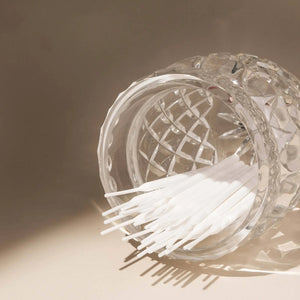 Brow Code Tinting Sticks 25-pack displayed in a clear textured glass jar with soft lighting casting shadows on a neutral surface