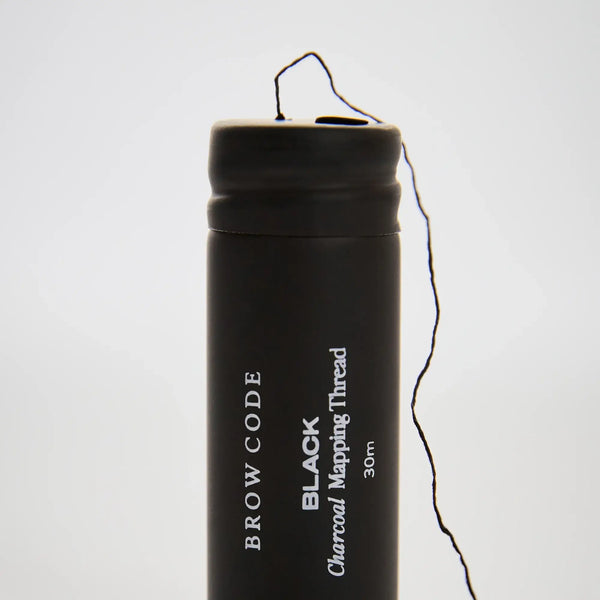 Brow Code Black Charcoal Mapping Thread 30m with visible thread emerging from spool, ideal for precise brow shaping and mapping accuracy