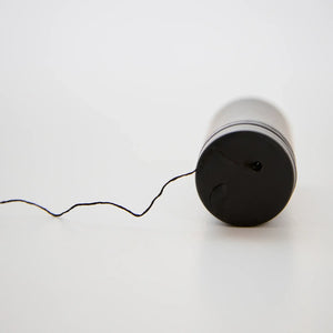 Brow Code Black Charcoal Mapping Thread with spool laying horizontally and thread extended, perfect for precise brow shaping techniques