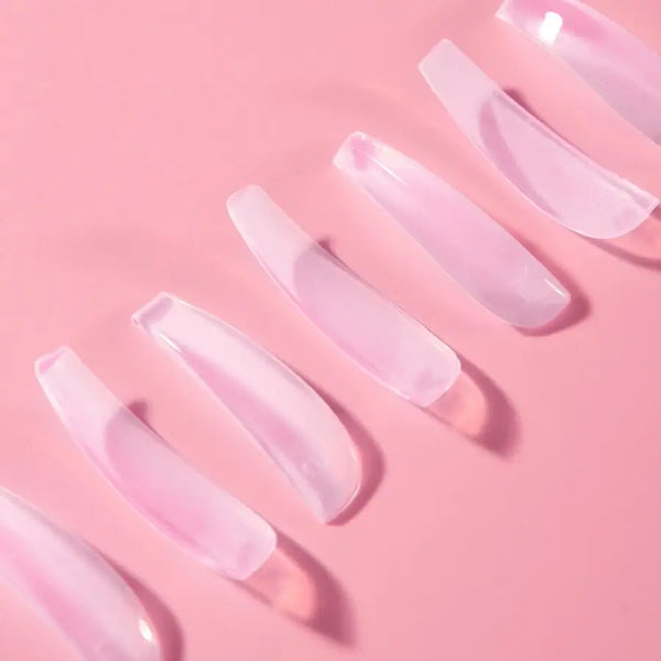 Pink ÉLAN WOW Lash Shields arranged in a row on a pink background, designed for professional lash lift procedures with a dramatic curl effect.